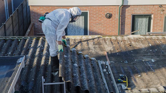 Worker in PPE removing Asbestos Roofing
