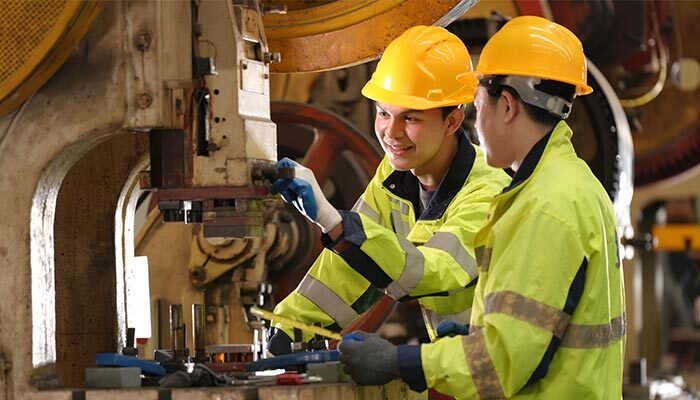 Civil engineer showing junior how to operate machine