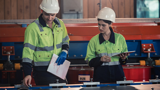 female and male factory worker managing risks together