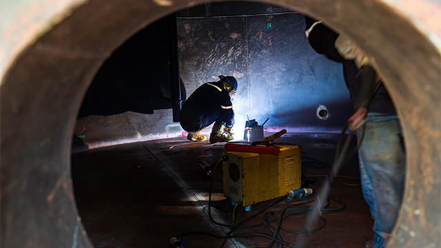 Two workers inside a confined space tunnel
