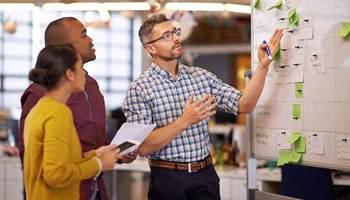 Employee demonstrating calendar plan to colleagues