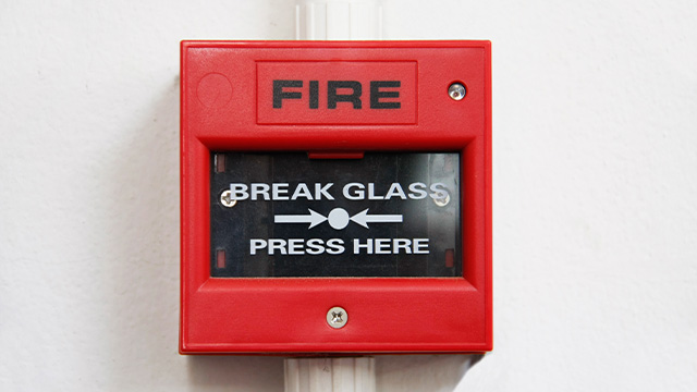 Fire alarm that has break glass press here written on it