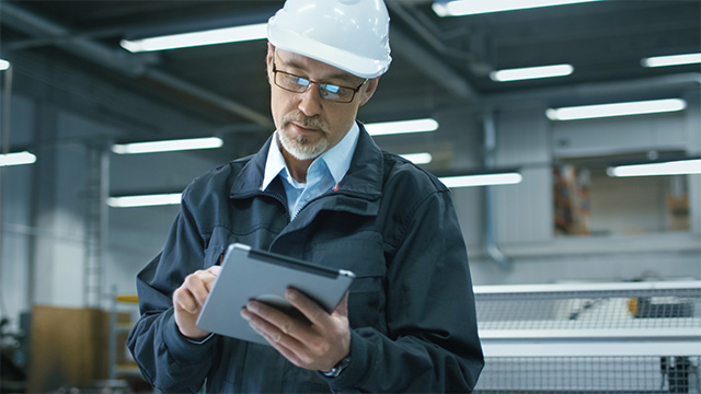 Factory Worker Looking at Tablet For Quality Management 