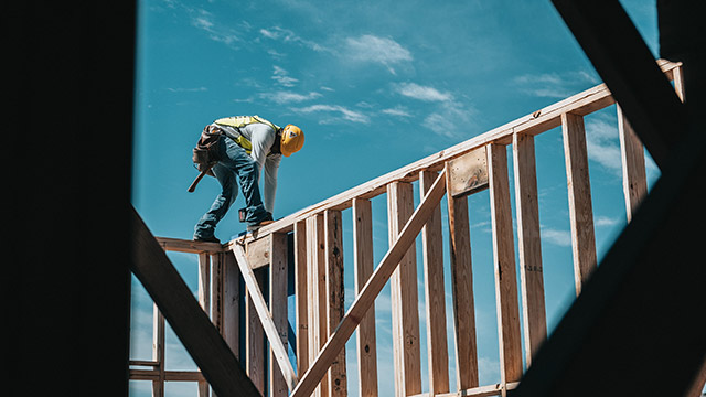 Builder standing on wall frames