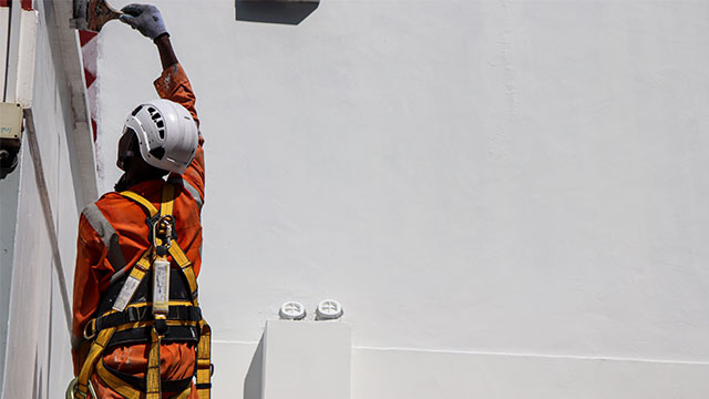 Worker wearing harness conducting work