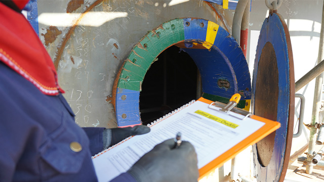 Worker doing a risk assessment on a confined space before beginning work