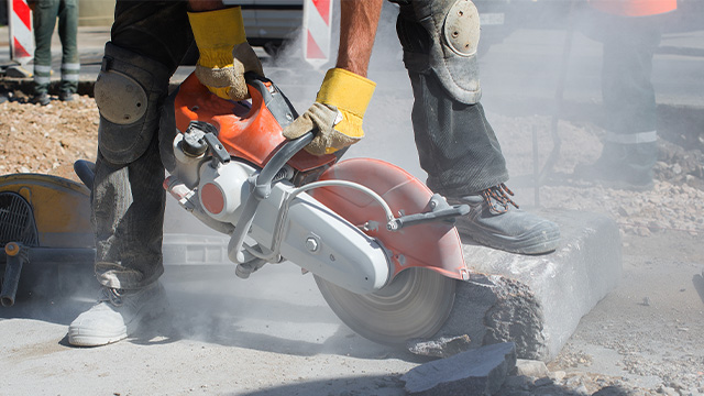 Worker cutting concrete