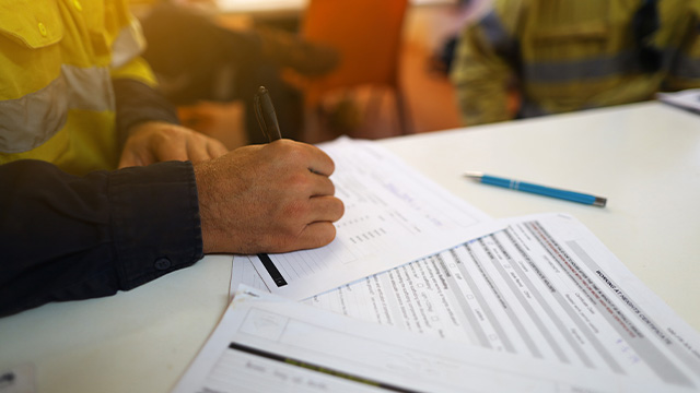 Construction worker filling out a safety operating procedures template