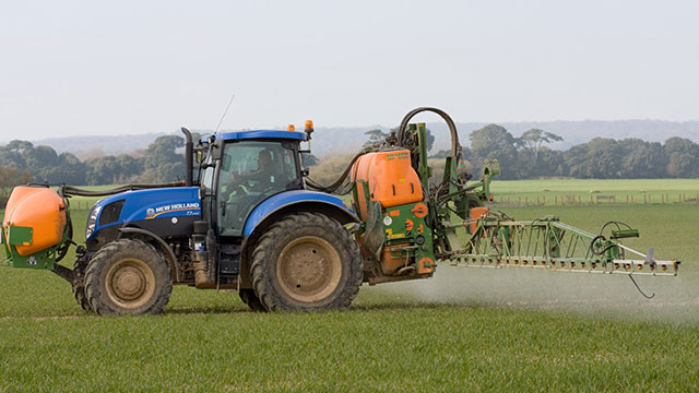 Tractor spraying crop chemicals