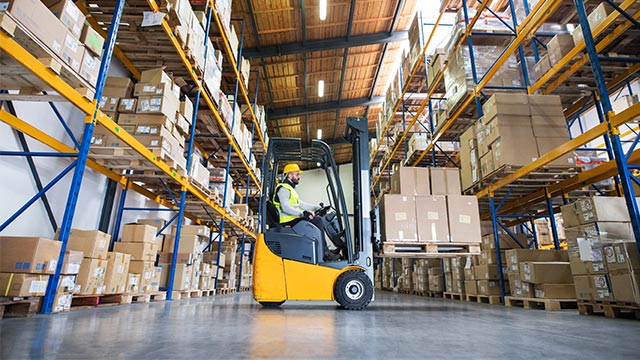 Warehouse worker driving forklift